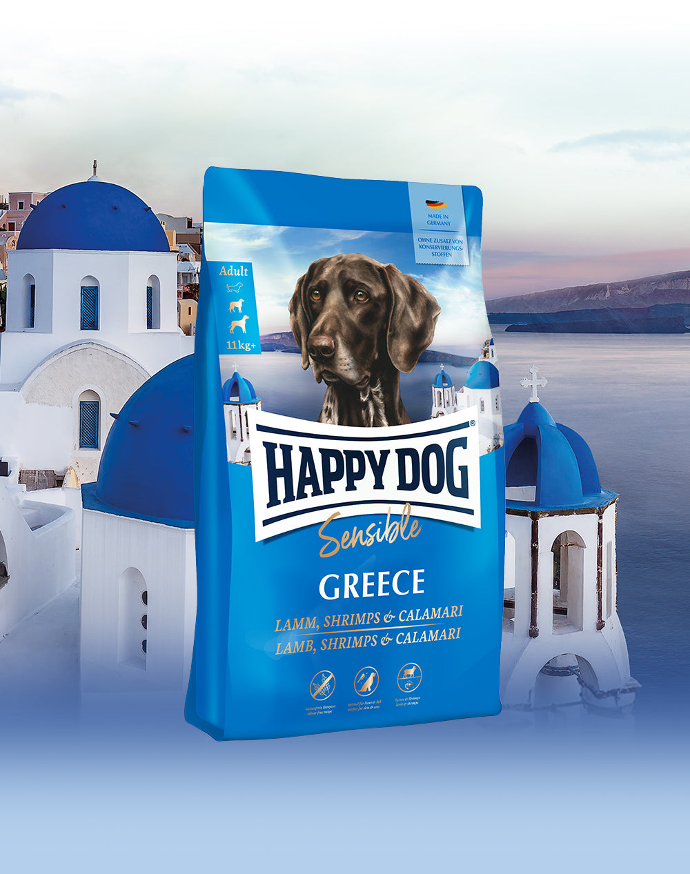 Das Hundefutter Happy Dog Sensible Greece, abgebildet vor einer typisch griechischen Inselkulisse mit weiß-blauen Häusern.